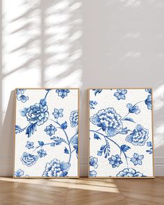 two blue and white floral paintings on the wall