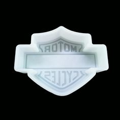 a motorcycle emblem is shown on the side of a white plastic tray with black background