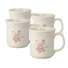 four white mugs with pink flowers on the front and bottom, one is empty