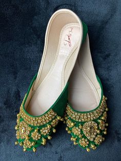 The Royal Green & Gold Jubilee Khussa is more than just a shoe, it's a statement offering a perfect blend of style and comfort, allowing you to dance the night away at weddings, festive celebrations, or cultural gatherings. The Royal Green and Gold Jubilee Khussa features a rich green velvet base, meticulously handcrafted using premium quality materials to ensure unmatched comfort and durability. The luxurious gold embellishments, adorned with shimmering diamonds, embellish every inch of this kh Fairy Shoe, Fairy Shoes, Punjabi Jutti, Royal Green, Gold Embellishment, Rich Green, Green Velvet, Green Gold, Green And Gold