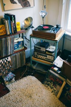 a record player sitting on top of a table next to a pile of books and records