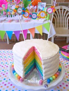 there is a cake that has been cut in half with rainbow decorations on the top