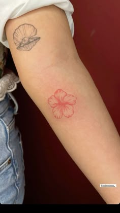 a woman's arm with a flower tattoo on the left side of her arm