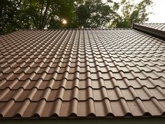 the roof of a house that has been coated with shingles and is brown in color