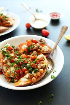 a white plate topped with baked potatoes covered in veggies