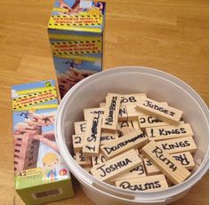 a bucket filled with wooden scrabbles next to a box of children's books