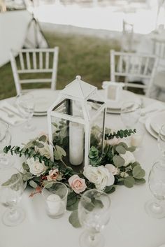 a white table with flowers and candles on it