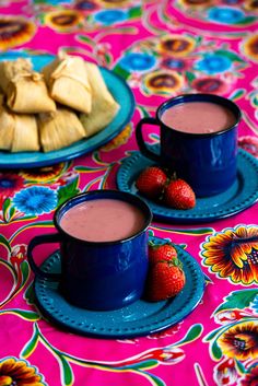 two cups of hot chocolate with strawberries on the side