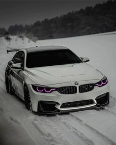 a white car driving down a snow covered road