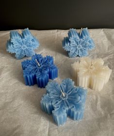 four blue and white candles sitting on top of a table