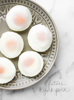 four fried eggs in a bowl on a marble table