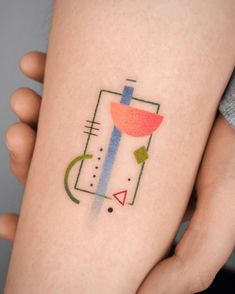 a woman's arm with a tattoo on it that has geometric shapes and colors