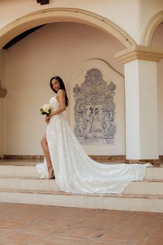 a woman in a wedding dress standing on some steps