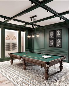 a pool table is in the middle of a room with green walls and ceiling lights