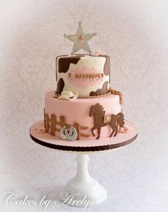 a pink and brown birthday cake sitting on top of a white pedestal