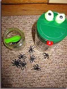 a green cup with googly eyes sitting on the floor next to some spider webs