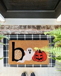 a door mat with two pumpkins and a ghost on it