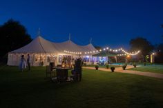 a large tent is lit up with string lights