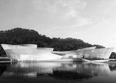 black and white photograph of the exterior of a building with water in front of it