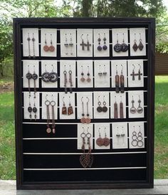 a display case filled with lots of different types of earrings on it's sides