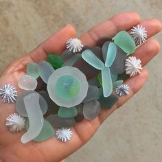 a person holding some sea glass in their hand