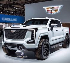 a white truck is on display at an auto show