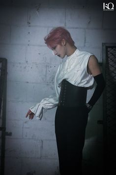 a woman with pink hair and black pants