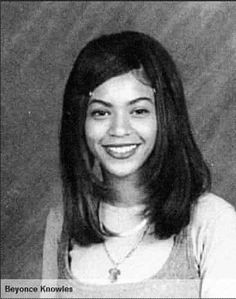 an old black and white photo of a young woman with long hair smiling at the camera