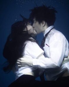 a man and woman kissing under the water