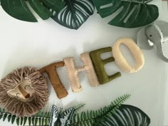 the word ohoh spelled out with stuffed animals and leaves on a white table top