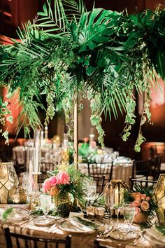 a table topped with lots of greenery and candles