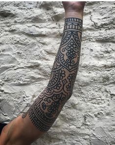 a man's arm with an intricate tattoo design on the left side of his arm