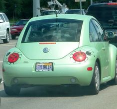 the back end of a green car with ladybugs painted on it