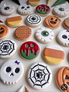 halloween decorated cookies are arranged on a white surface with spooky eyes and spider webs