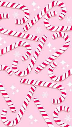 christmas candy canes on pink background with snowflakes and stars in the background