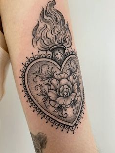 a woman's thigh with a heart and flower tattoo design on the side of her leg