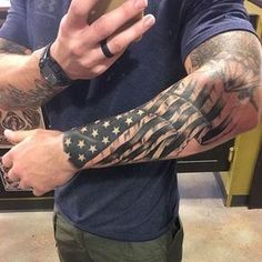 a man is taking a selfie with his cell phone while wearing an american flag tattoo