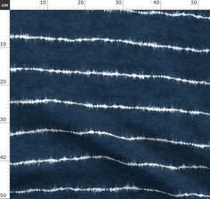 an image of blue and white fabric with lines on the bottom, in front of a ruler