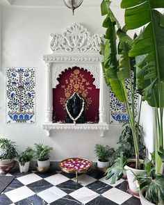 there is a statue in the corner of this room with potted plants and other decorations