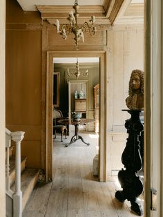 an old house with wood floors and chandelier hanging from the ceiling in front of it