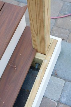 a wooden bench sitting on top of a sidewalk