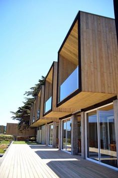 an exterior view of a house with wooden sidings and glass doors on the outside