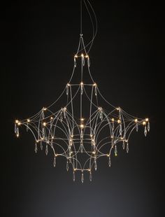 a chandelier with lights hanging from it's sides in a dark room