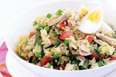 a white bowl filled with rice and veggies next to an egg on top