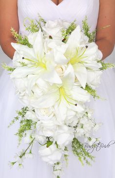 a bride holding a bouquet of white flowers