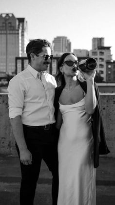 a man and woman standing next to each other in front of a cityscape