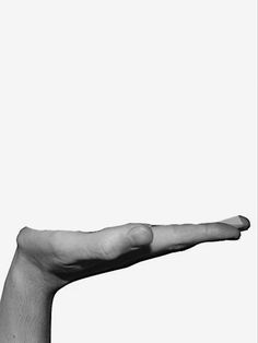 a black and white photo of a person's hand holding an object in the air