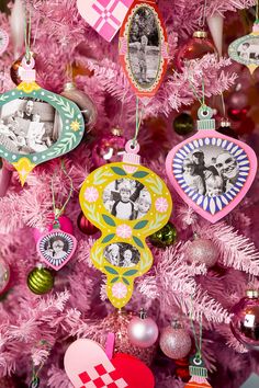 a pink christmas tree with ornaments and pictures on it