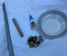 a white plate with blue and gold designs on it next to some other items that include beads