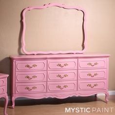 a pink dresser with a mirror on top of it